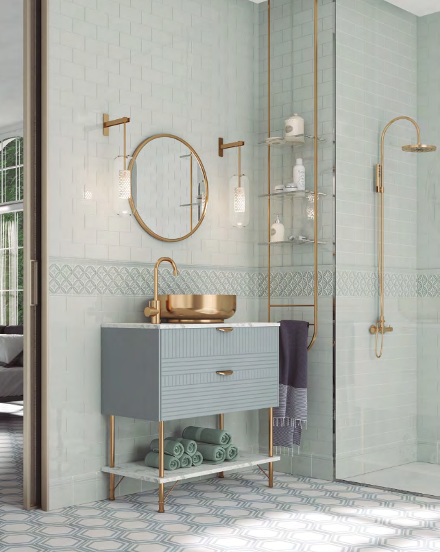 Elegant bathroom with light blue tiles, gold fixtures, vanity, mirror, and shower.