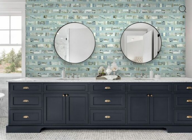 Bathroom vanity with blue brick tile backsplash, dark blue cabinets, two round mirrors.
