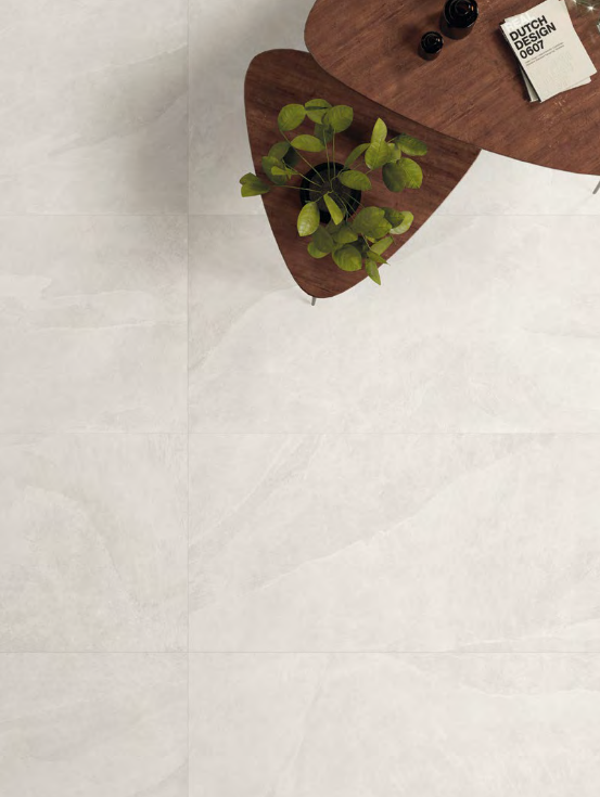 Top-down view of two wooden tables with plants, books, and drinks, over a white stone floor.