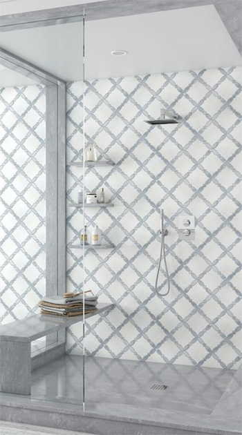 A modern shower with white and gray diamond tile, glass door, built-in bench, and shelves.