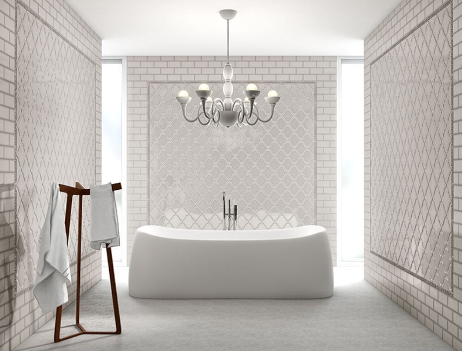 Elegant white bathroom with a freestanding tub, chandelier, and decorative wall tiles.