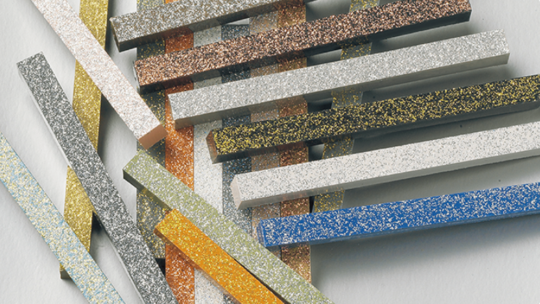 Various colored glittery ceramic strips, arranged and overlapping.