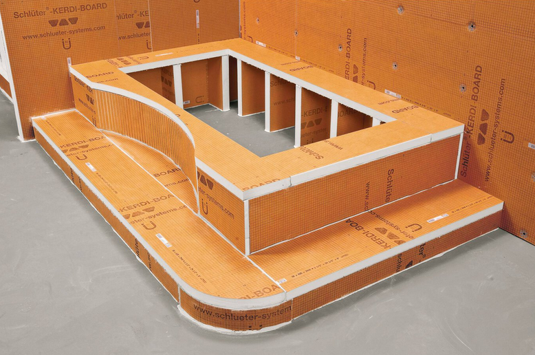 Orange foam construction forming a shower base with steps and a curved design.