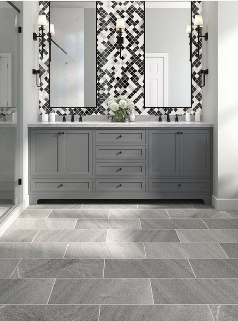 Gray bathroom with double vanity, gray tile floor, and patterned accent tile.