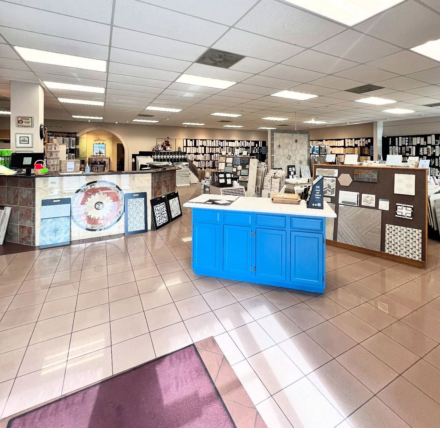 Interior of a tile store with tile displays and a blue counter.