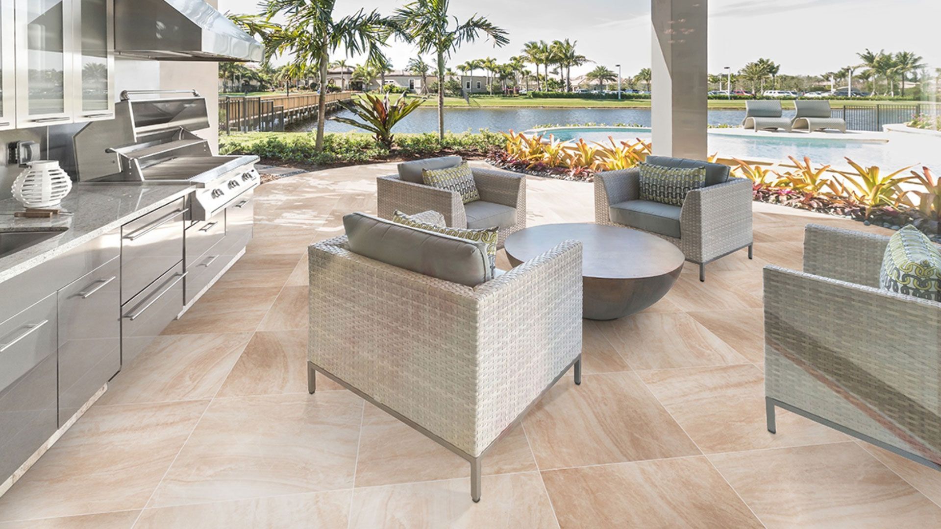 Outdoor patio with seating, a grill, and a view of a pool and water.