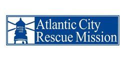 Logo for the Atlantic City Rescue Mission, featuring a blue lighthouse icon next to white text on a blue rectangle.