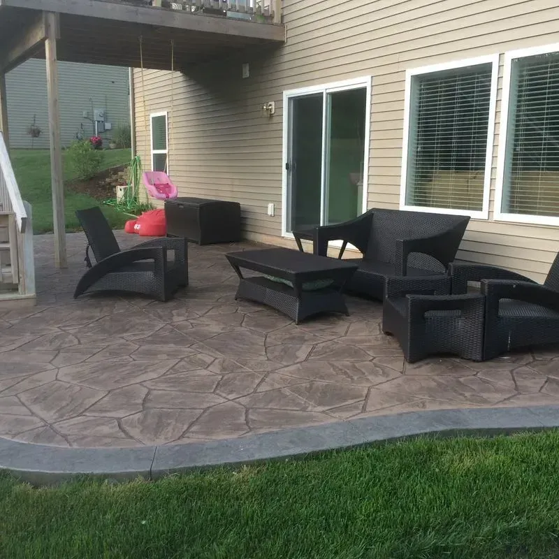 A patio with chairs and a table in front of a house