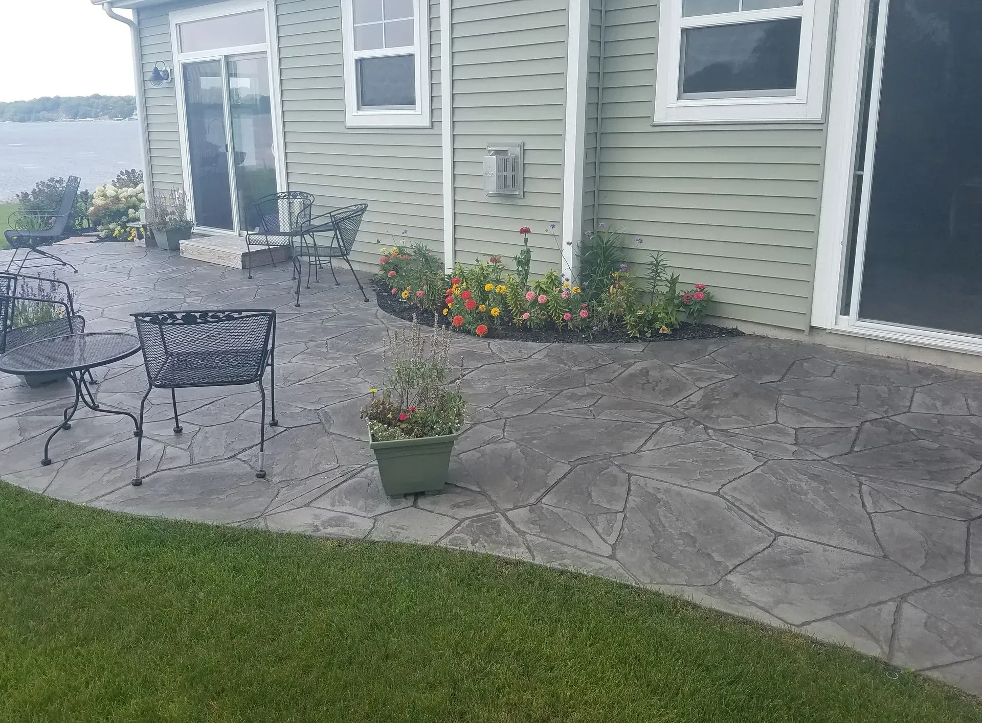 A patio with a table and chairs in front of a house.