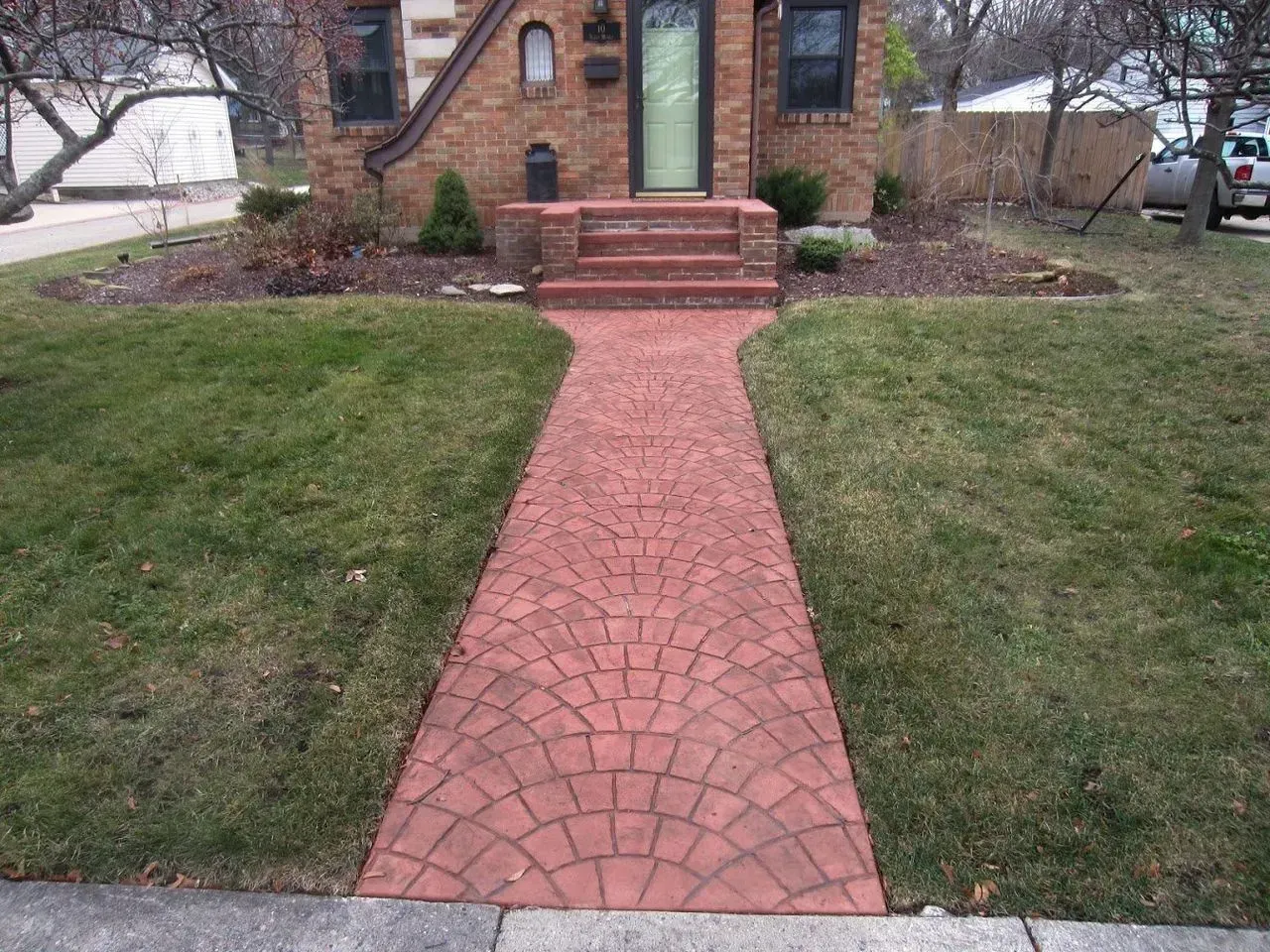 A brick walkway leading to the front door of a house
