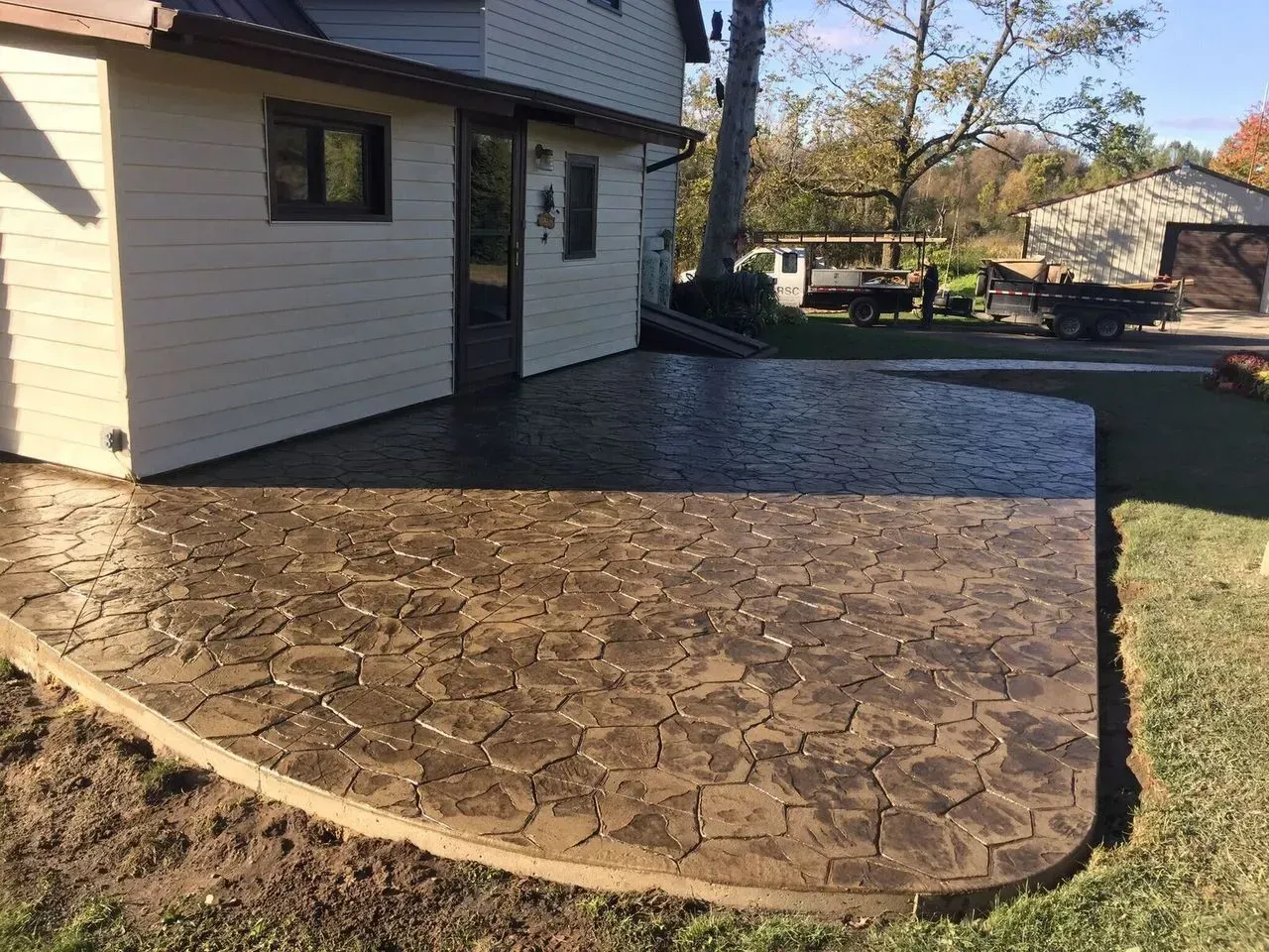 A concrete patio is being built in front of a house.