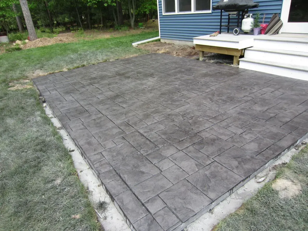 A patio is being built in the backyard of a house.