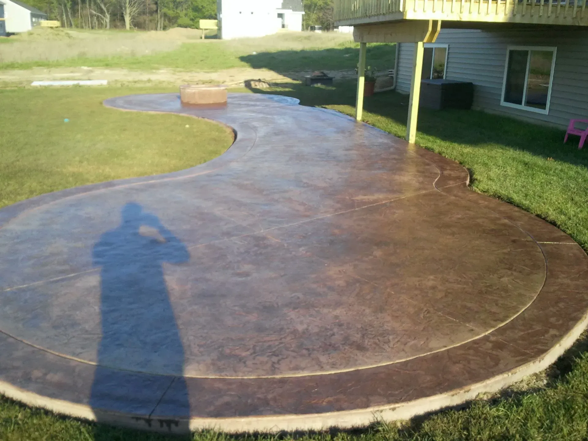 A concrete patio with a shadow of a person on it