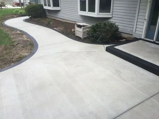 A concrete walkway leading to the front door of a house.
