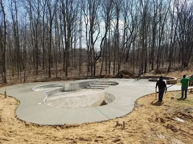 A concrete pool is being built in the middle of a forest.