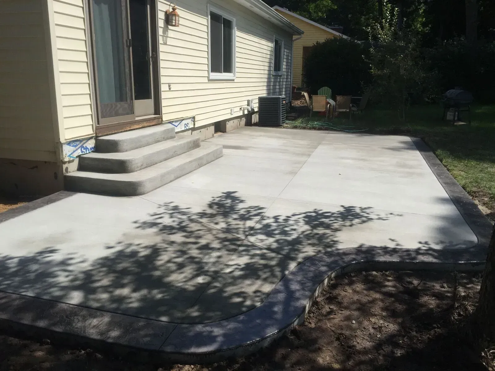 A concrete patio is being built in front of a house.