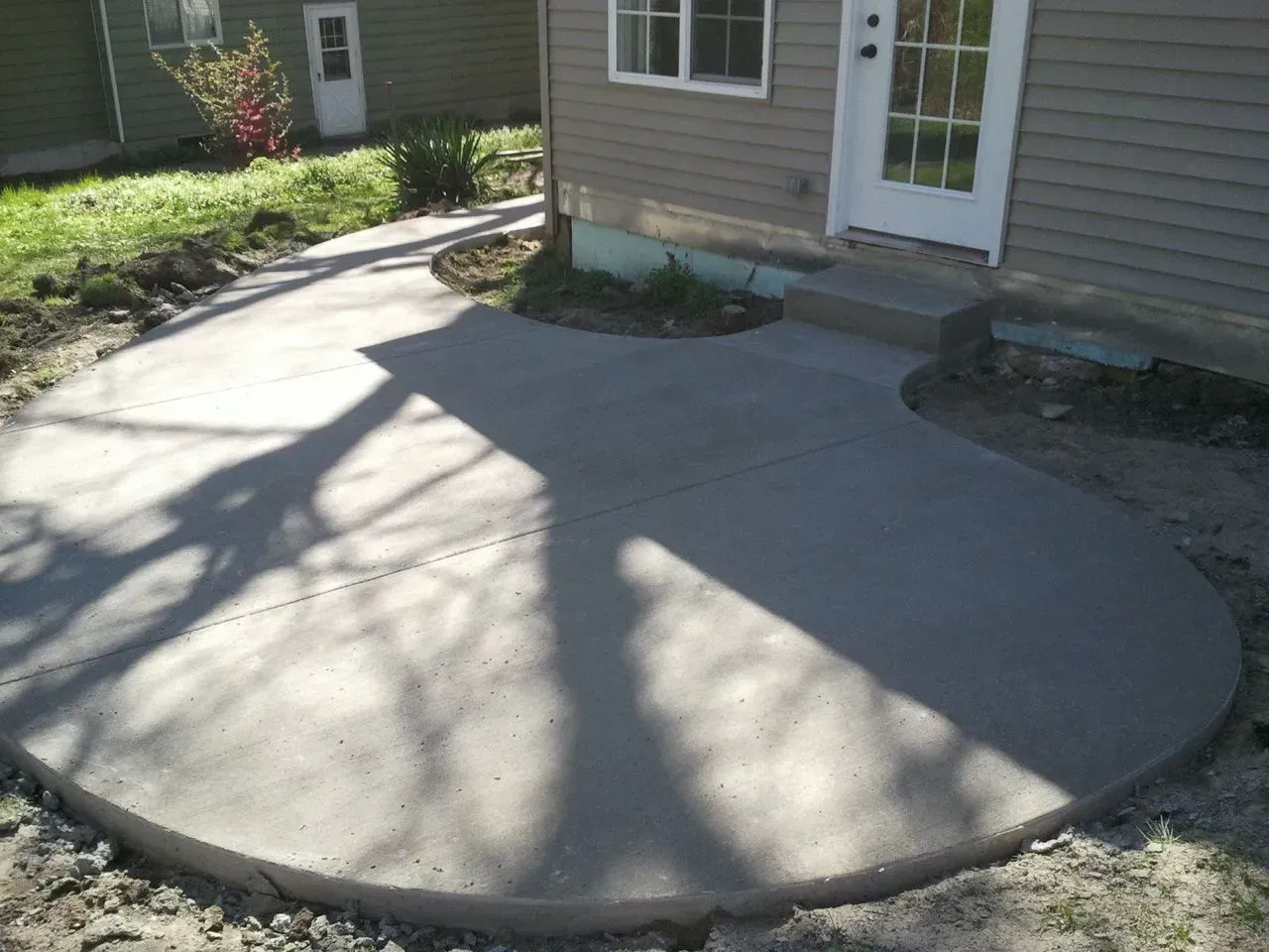 A concrete walkway is being built in front of a house