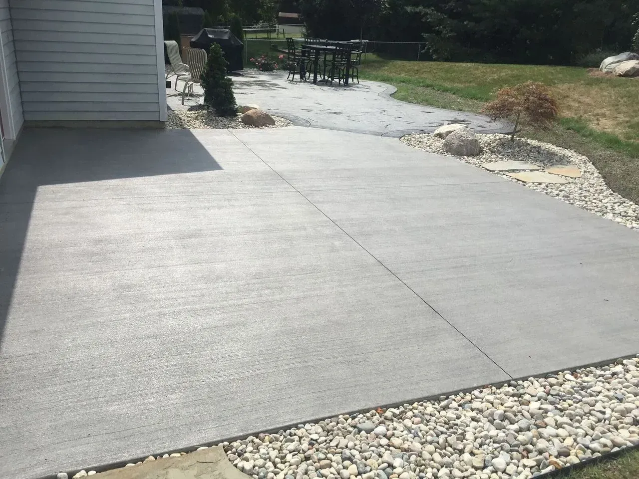 A concrete driveway with a patio in the background
