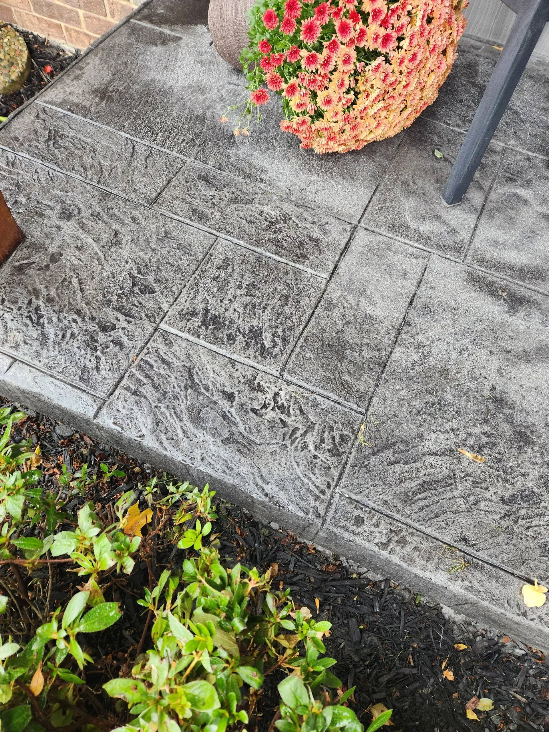 A concrete walkway with flowers in a pot on top of it.