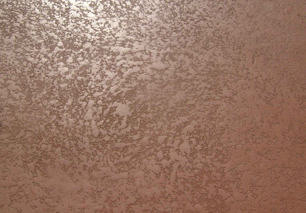 A close up of a brown wall with a metallic texture.
