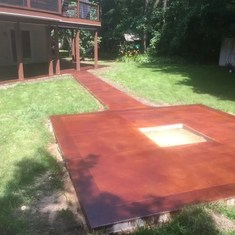 A concrete patio with a walkway leading to a house.