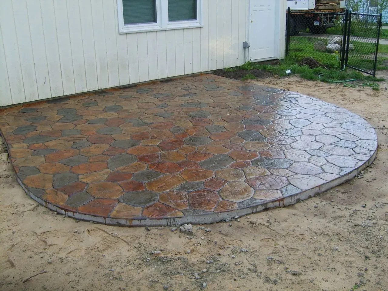 A patio is being built in front of a white house.