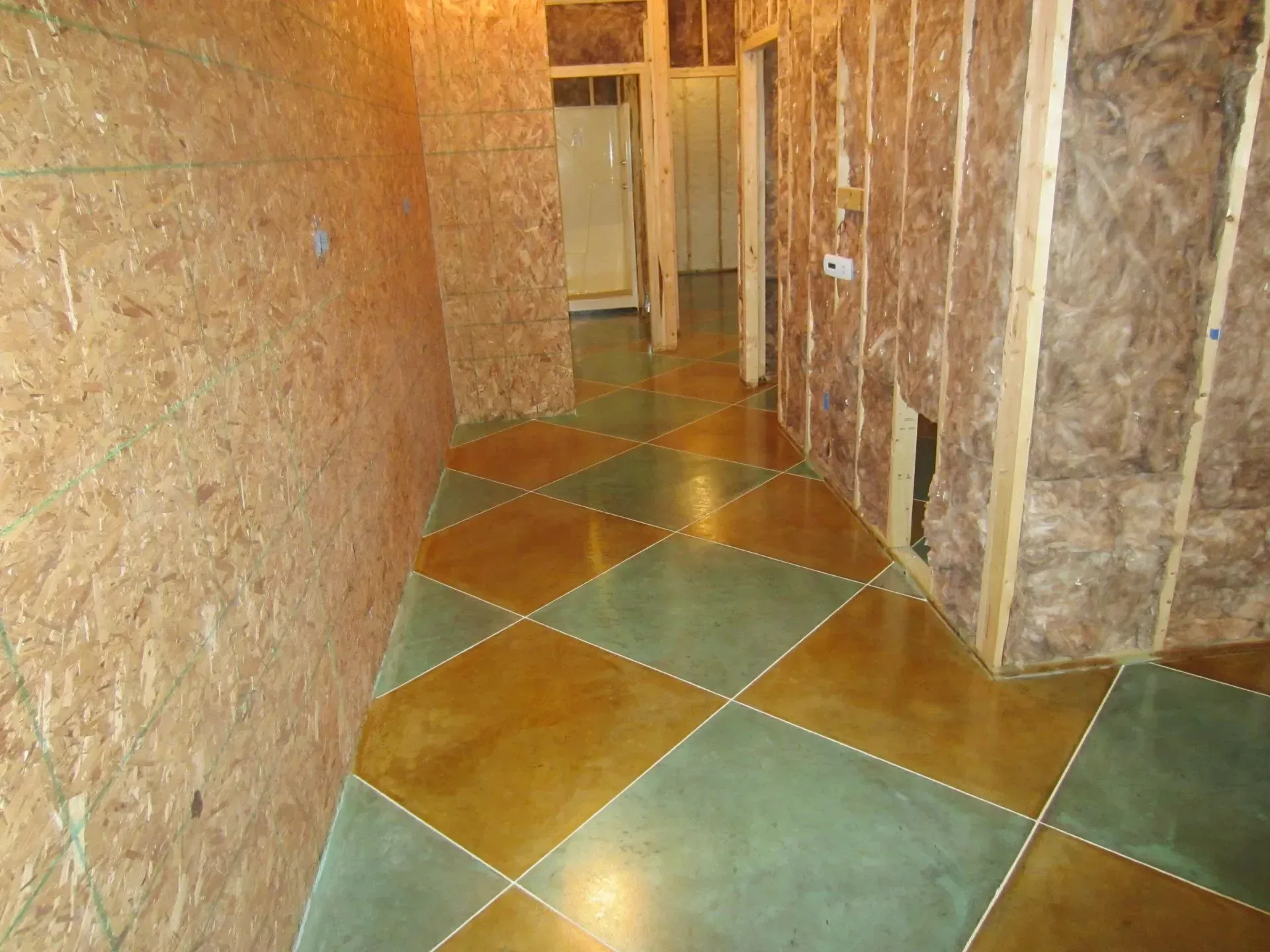 A hallway with a concrete floor and a wooden wall