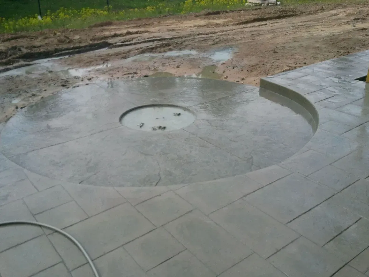 A concrete patio with a fire pit in the middle