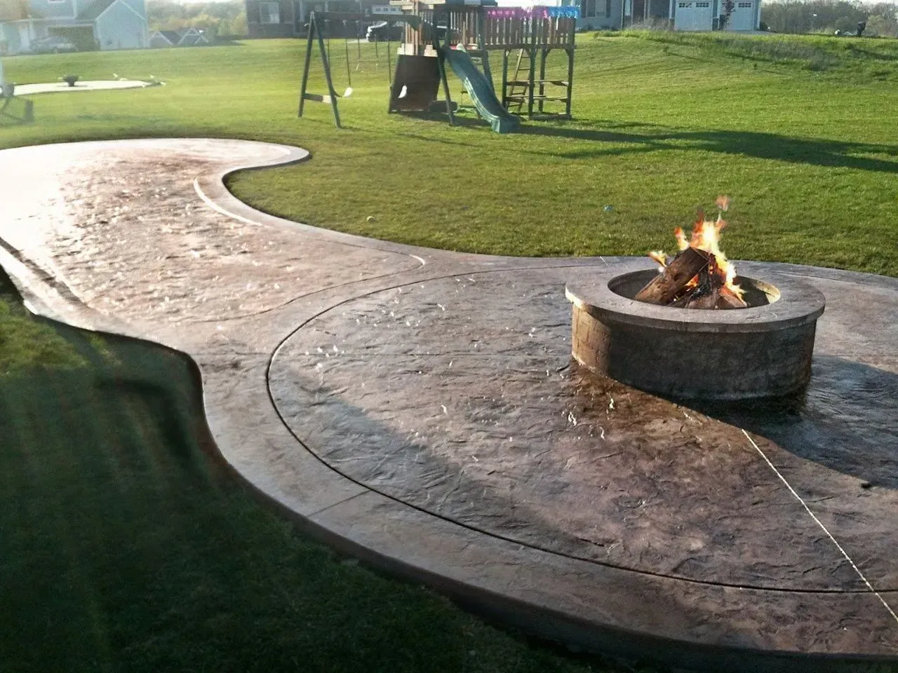 A fire pit with a playground in the background