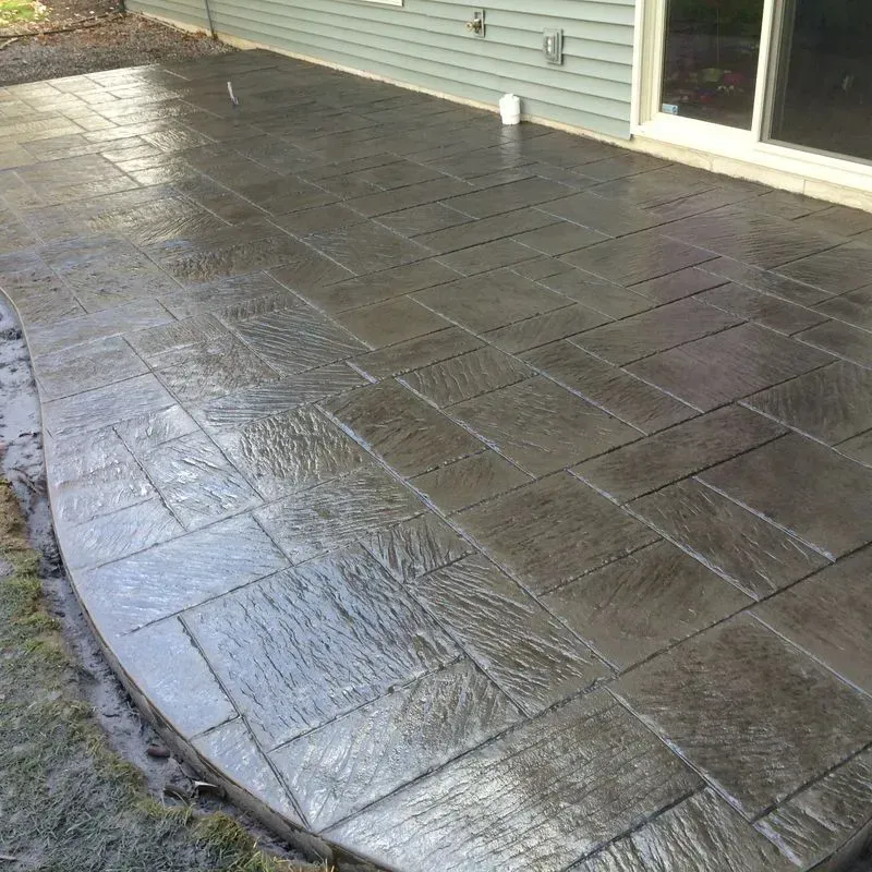 A concrete patio with a sliding glass door in the background.