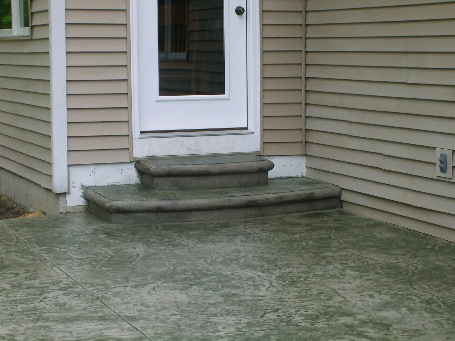 A house with concrete steps leading up to the door