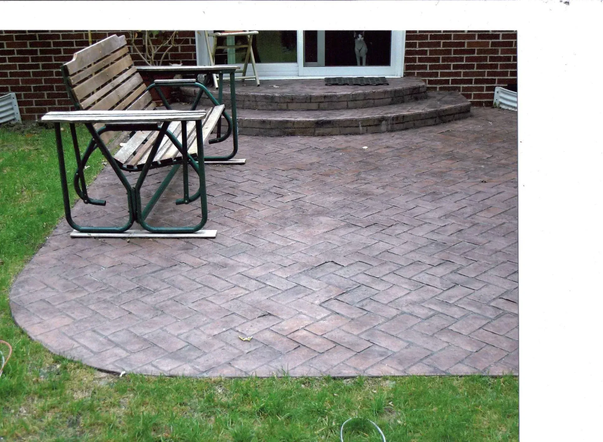 A brick patio with a picnic table and chairs
