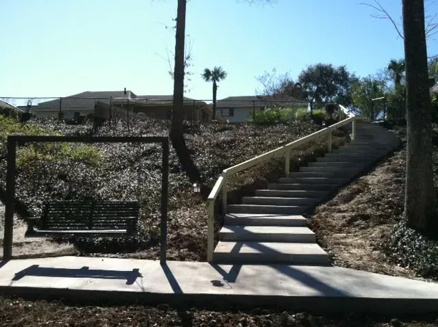 Stairs leading up to a house with a bench in the foreground