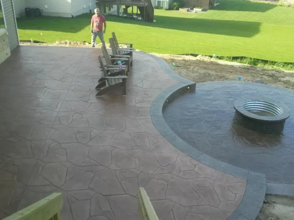 A man standing on a patio next to a fire pit