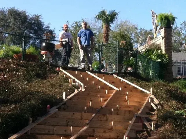 Two men standing on top of a wooden staircase