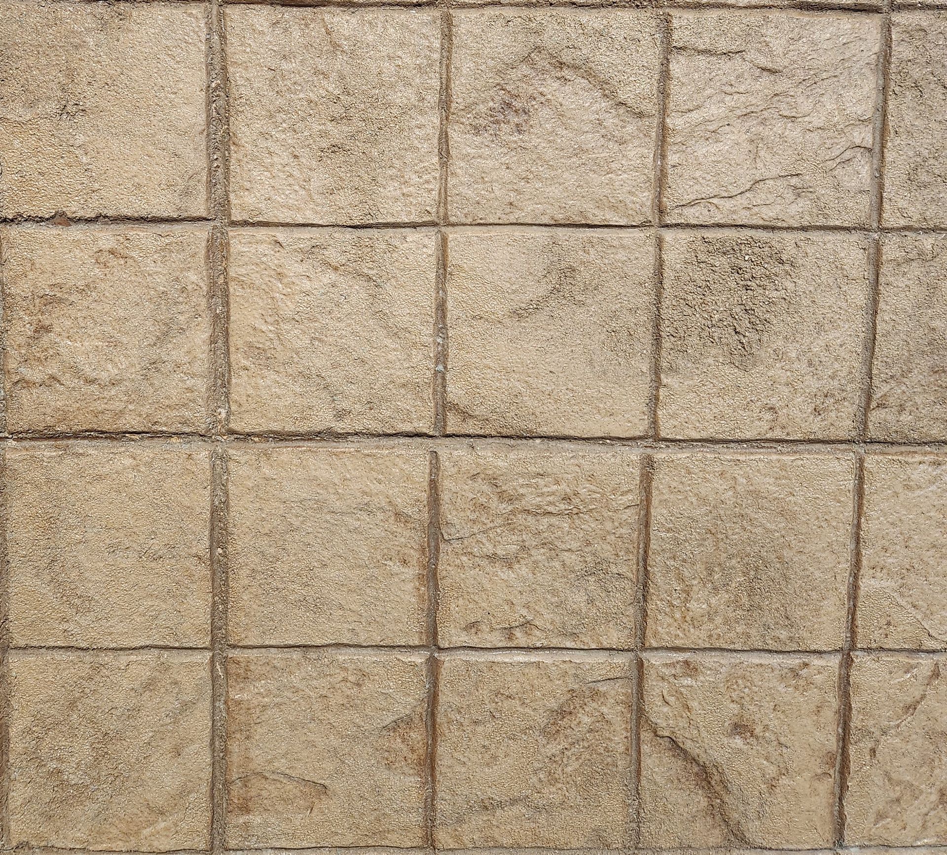 A close up of a brick wall with square tiles.