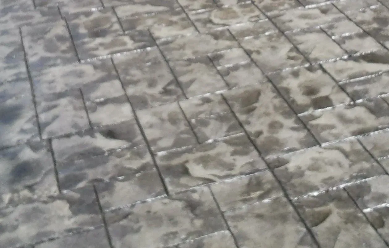 A close up of a concrete floor with a brick pattern