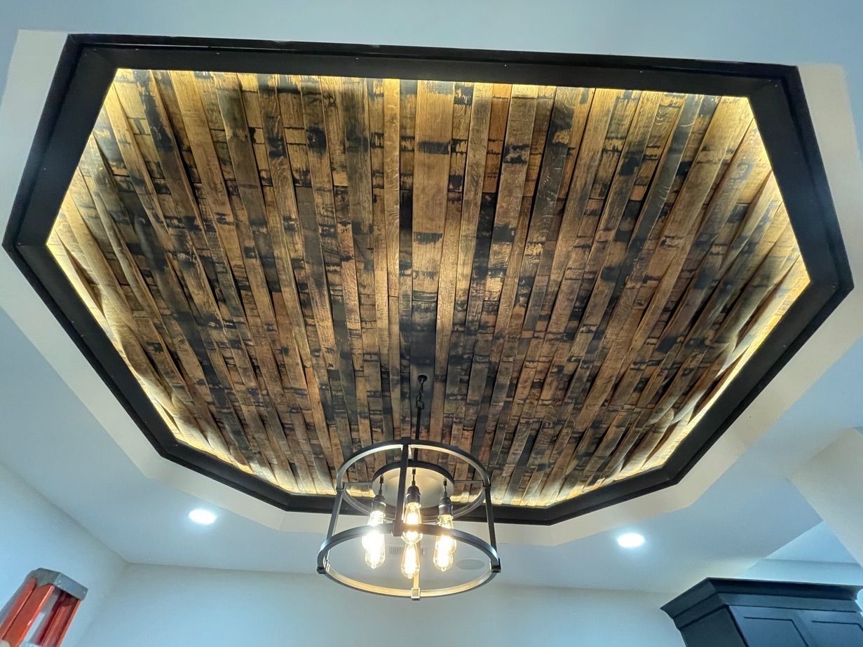 Wood-paneled octagonal ceiling with a central metal chandelier in a bright room