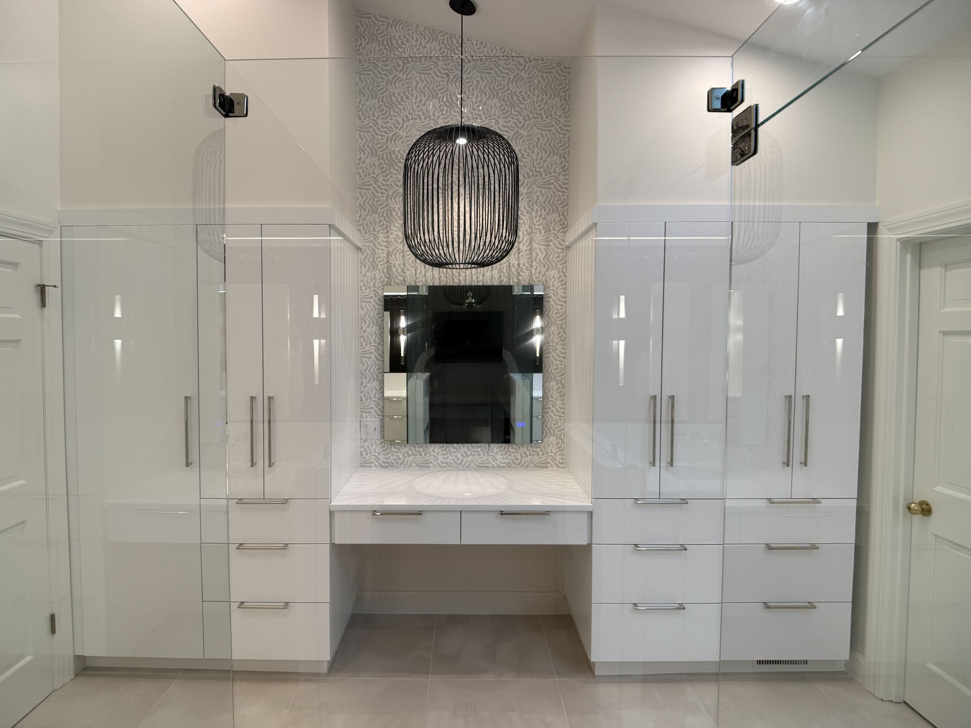 Modern white bathroom vanity with double cabinets, large mirror, and decorative pendant light.