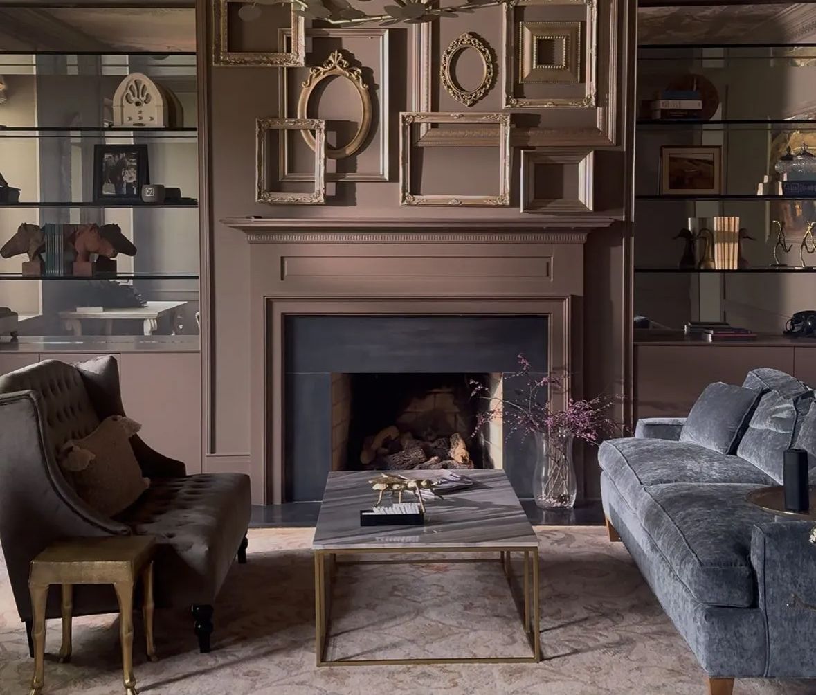 Elegant living room with fireplace, built-in shelves, and gray sofas around a coffee table.