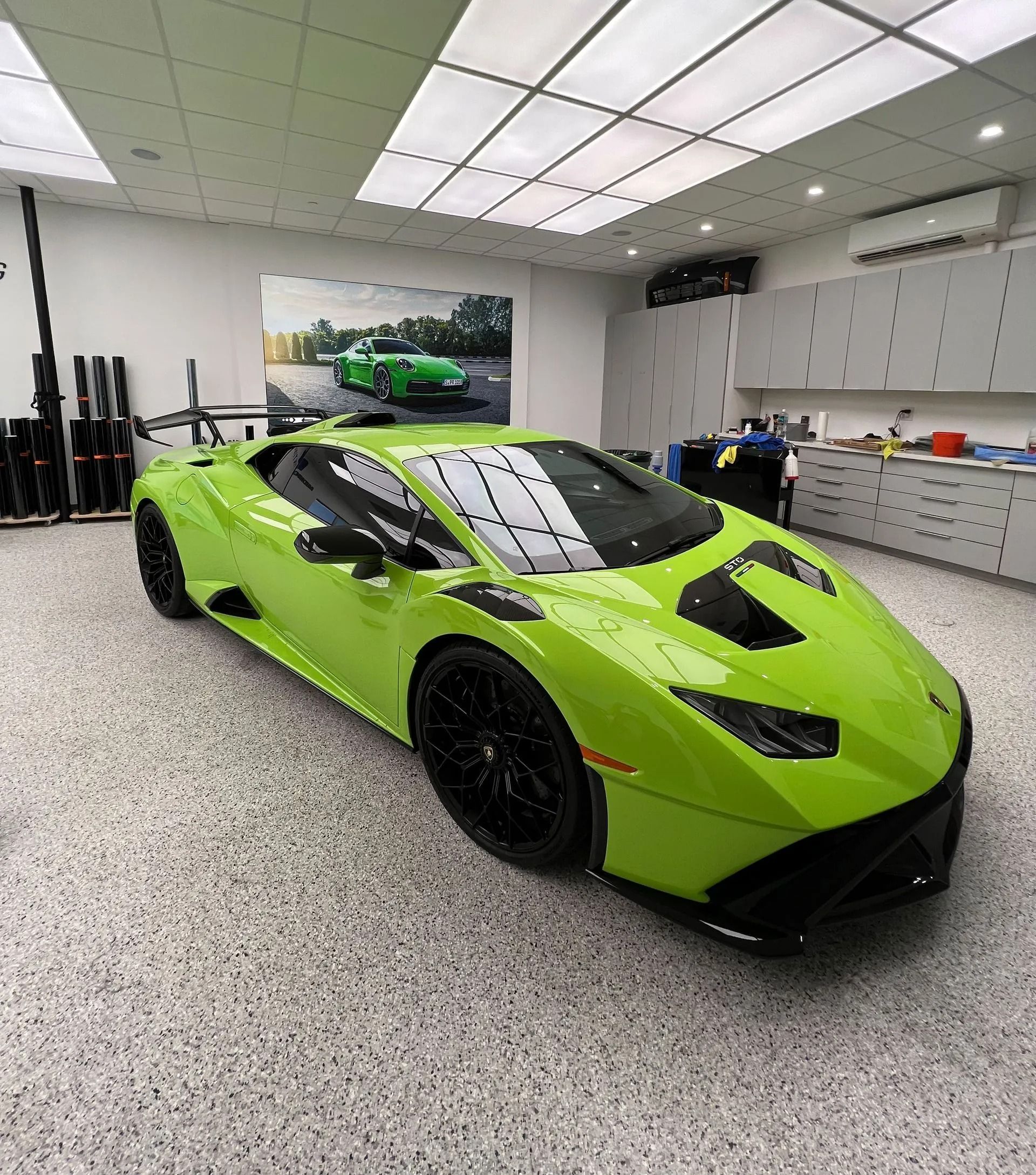 Lime green Lamborghini in a garage. Black wheels and spoiler.