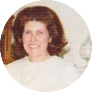 Portrait of a smiling person with dark curly hair wearing a white top