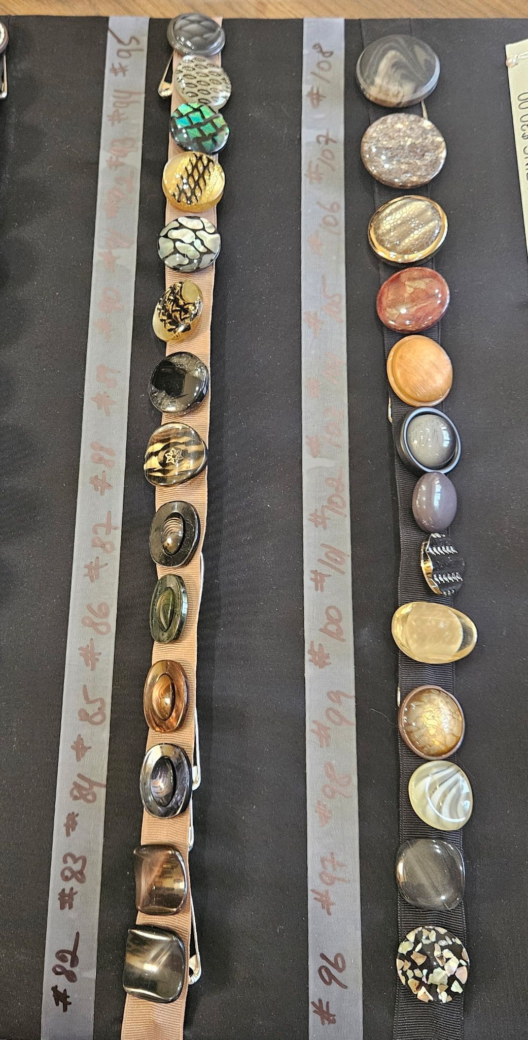 Vertical strips of round, colorful beads and stones arranged on gray background panels