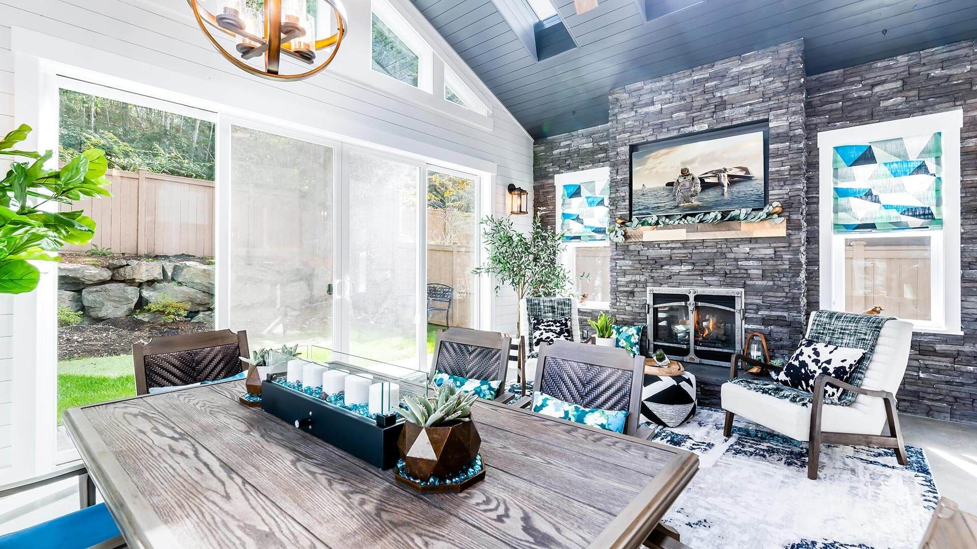 A dining room with a wooden table and chairs and a fireplace.