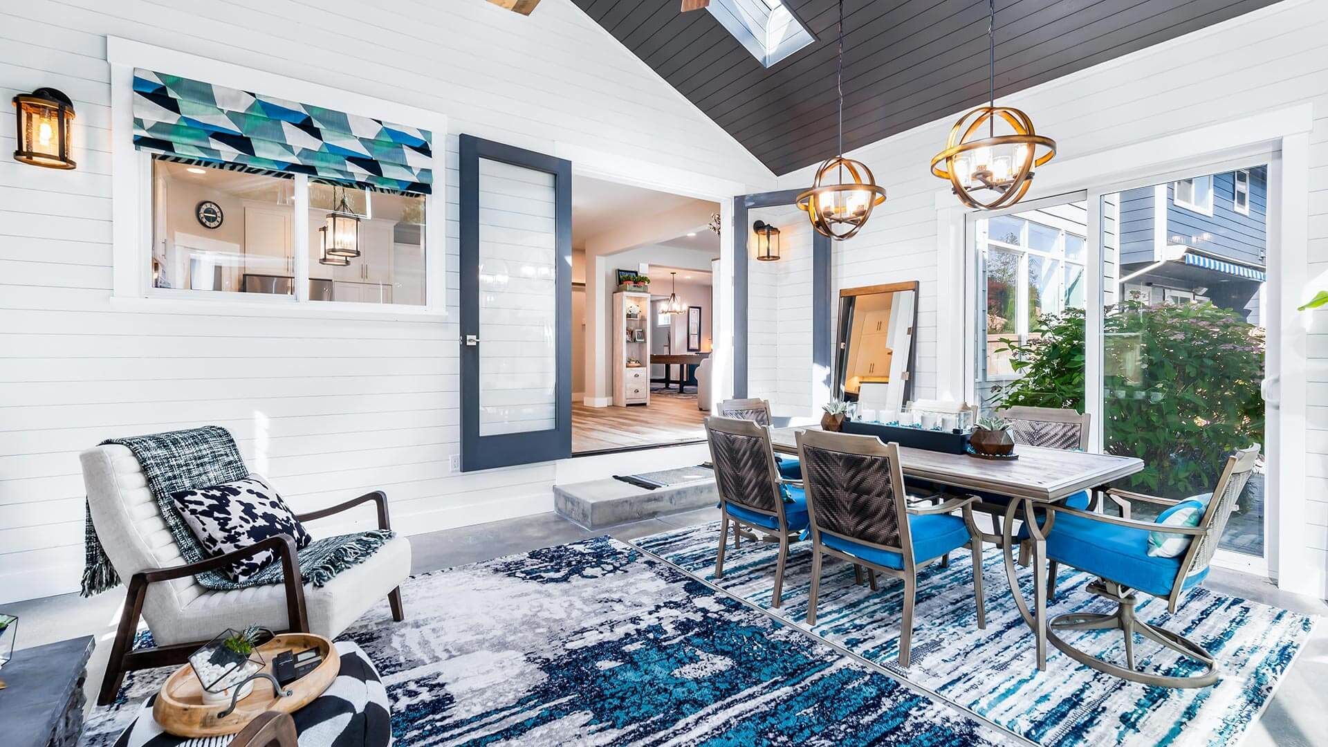 A living room with a table and chairs and a rug.