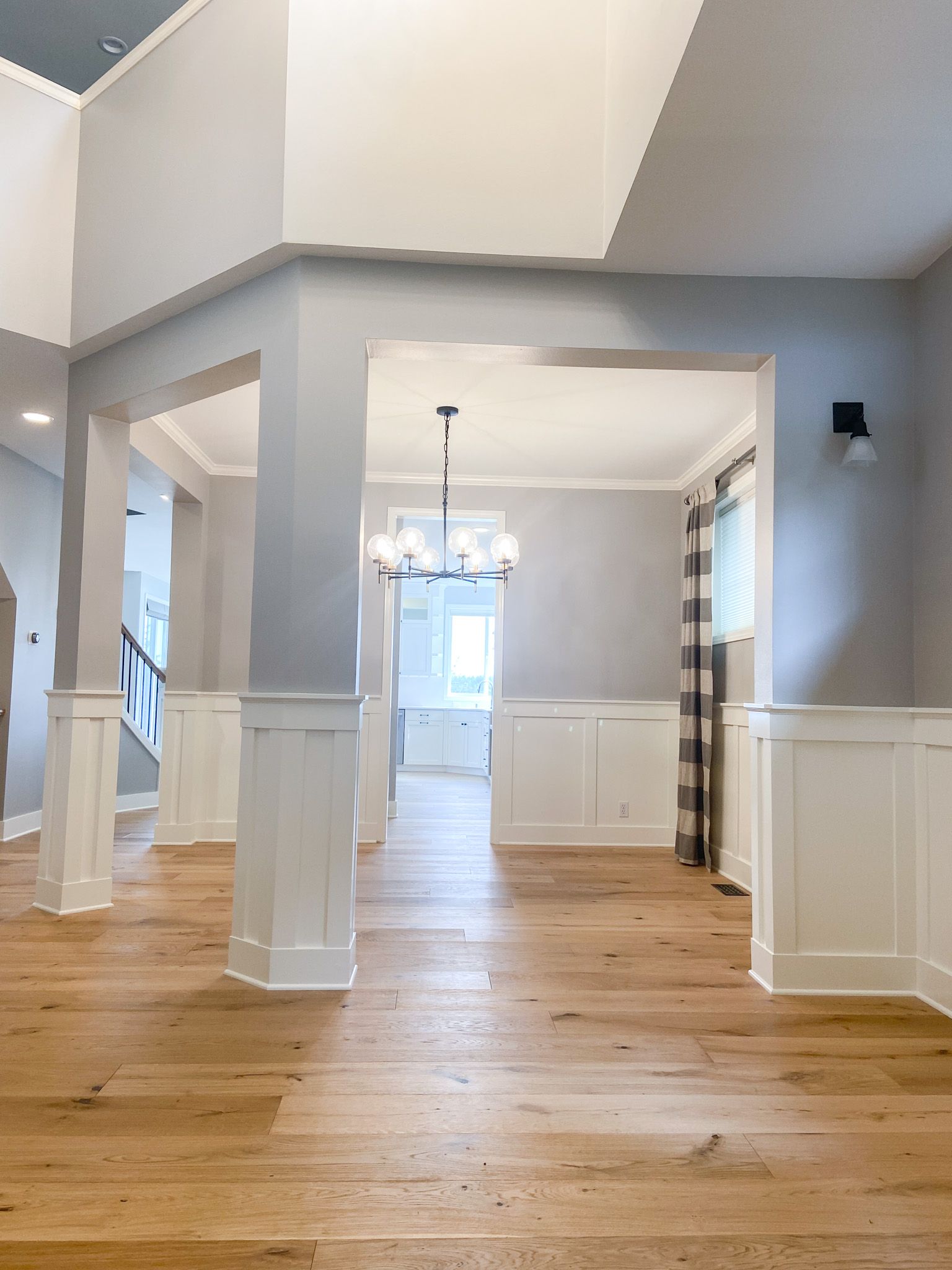 A large empty room with hardwood floors and gray walls