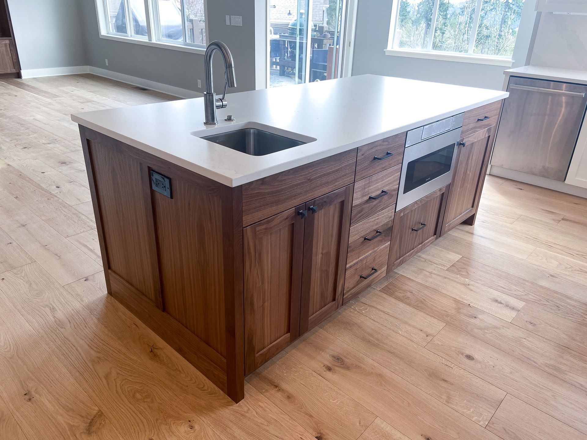 A kitchen with a large island with a sink and stainless steel appliances.
