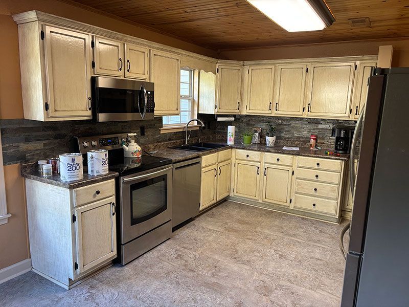 Kitchen with cream-colored cabinets, stainless steel appliances, and a gray countertop.