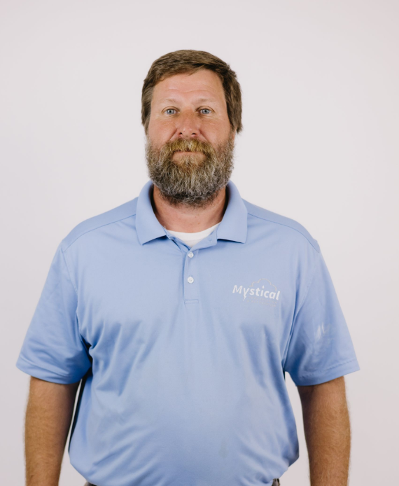 Man in a light blue polo shirt standing against a plain white background