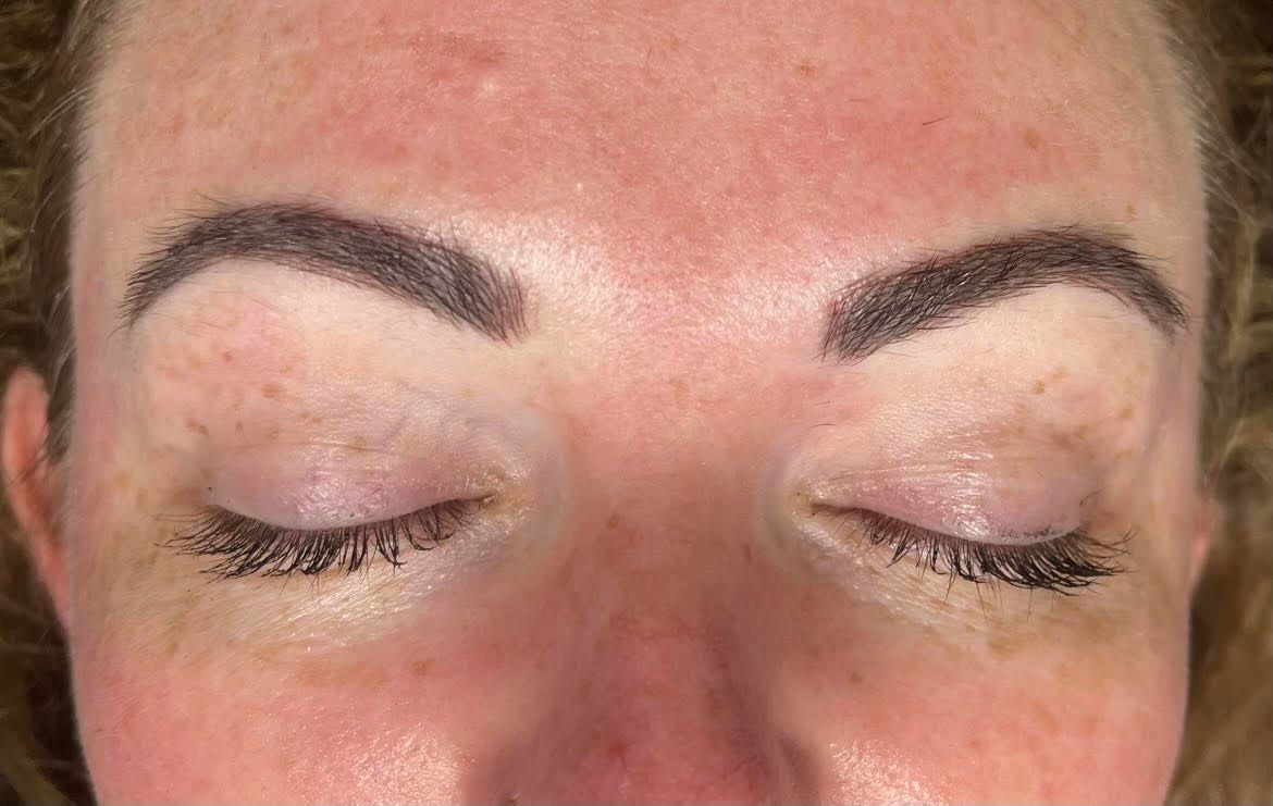 A close-up of a woman's face with her eyes closed.